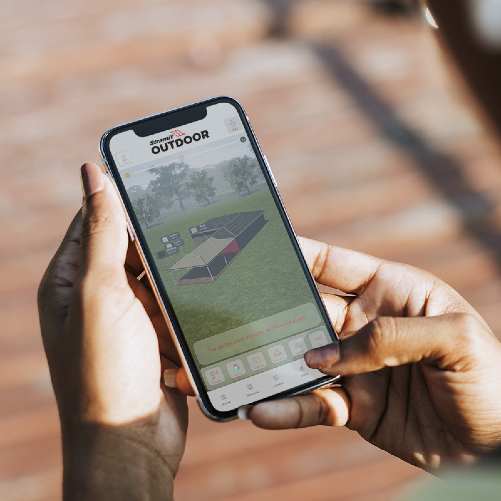 A pair of hands holding an iphone displaying the Stramit Outdoor app