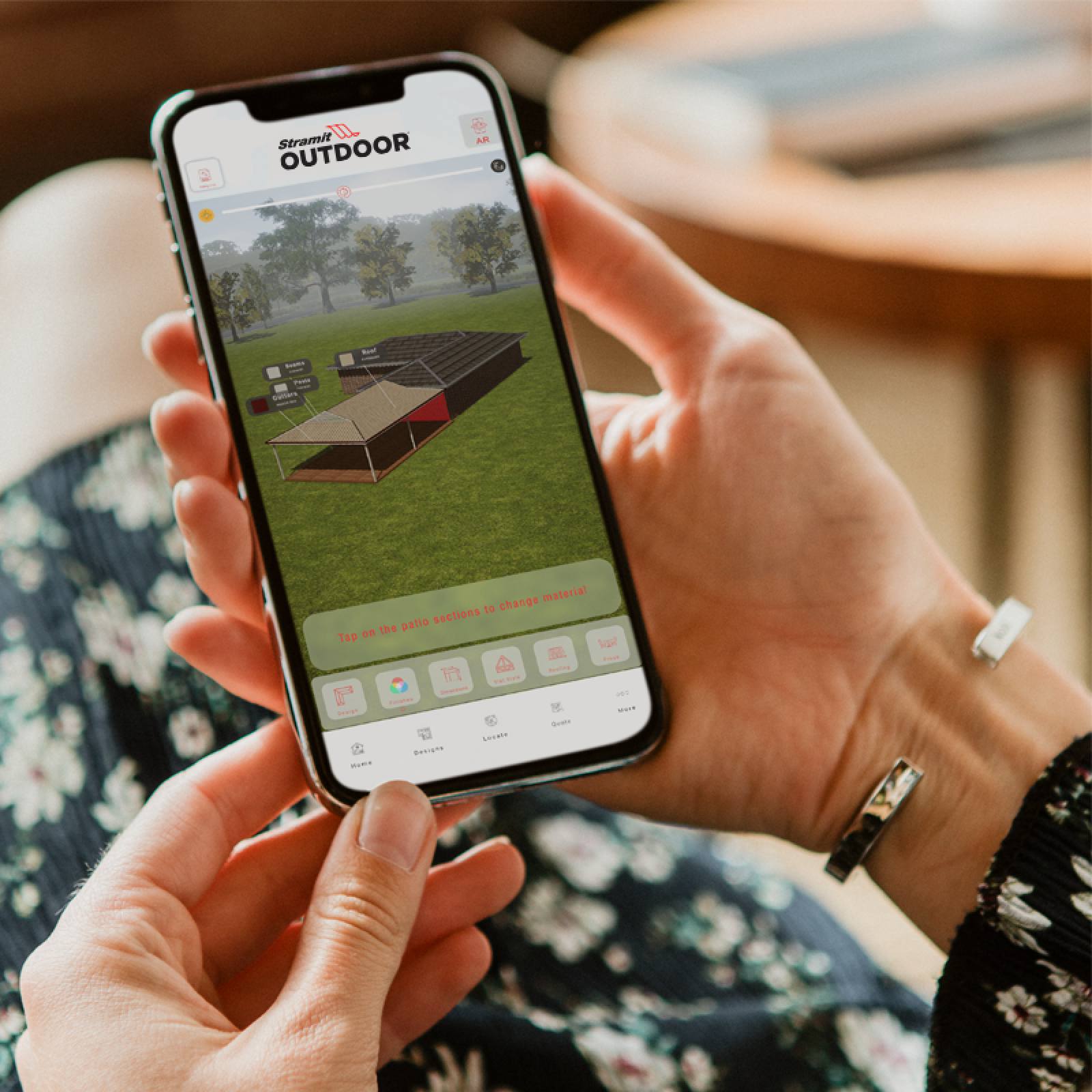 A pair of hands holding an iphone displaying the Stramit Outdoor app